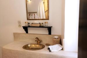 uma casa de banho com um lavatório dourado e um espelho em Riad de charme l'Oasis d'Essaouira - Suite Luxe em Essaouira