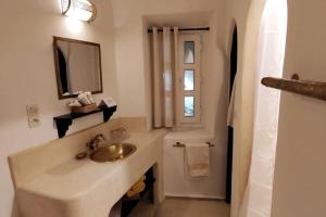 um banheiro com uma pia, um espelho e uma janela em Riad de charme l'Oasis d'Essaouira - Suite Luxe em Essaouira