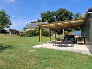 Un pabellón con sillas y una mesa en un patio. en Gite Sant Venter, en Plounevez-Quintin