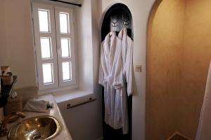 uma toalha pendurada numa parede ao lado de um lavatório em Riad de charme l'Oasis d'Essaouira - Suite Luxe em Essaouira mais 127 fotografias