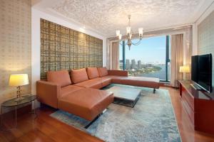 a living room with a couch and a television at The Reverie Saigon Residential Suites in Ho Chi Minh City