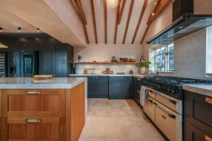 a large kitchen with blue cabinets and a stove at Merryweather in Canterbury