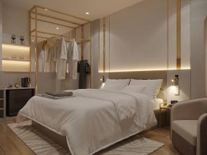 a bedroom with a large white bed and a chair at MAYS Grand Hotel & Spa - Ben Thanh in Ho Chi Minh City