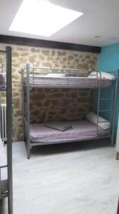 2 letti a castello in una camera con muro di mattoni di Spacieuse maison avec piscine partagée à Razès a Razès