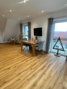 sala de estar con suelo de madera y mesa en Ferienwohnungen Zimmermann, en Bad Waldsee