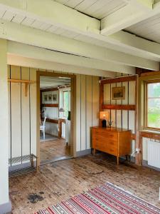 Renovated Cottage By Lake Rydbos في ألينغساس: غرفة فارغة مع مكتب ومرآة