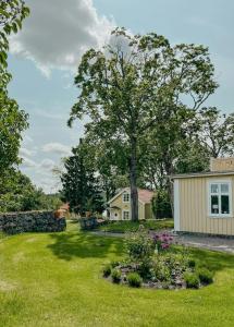 Renovated Cottage By Lake Rydbos في ألينغساس: ساحة بها منزل وشجرة