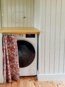 Renovated Cottage By Lake Rydbos في ألينغساس: ميكروويف أبيض في مطبخ مع كونتر