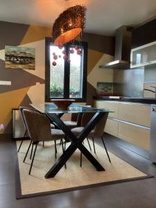 a dining room with a glass table and chairs at L'Eugenie in Pierrefonds