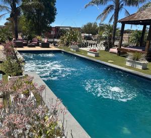 a swimming pool with blue water in a yard at Belclaren in McLaren Vale