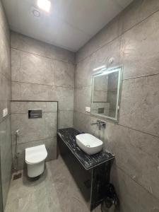 een badkamer met een wastafel, een toilet en een spiegel bij Hotel Shree Rajasthan Inn in Ajmer +19 foto's