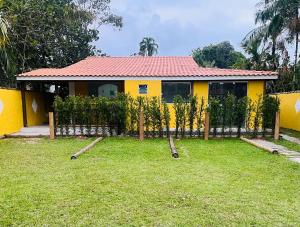 a yellow house with a fence in front of it at Chalés Boraceia Duda in Boracéia