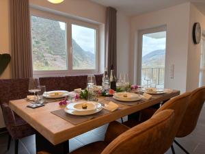 Una mesa de comedor con sillas y una gran ventana. en FeWoMo Premium Mosel Fewo an der Promenade in Cochem mit Burgblick barrierefrei bis 6 Personen, en Cochem
