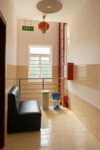 una sala d'attesa con una sedia nera e una finestra di Thái Dương Hotel a Tân Hội