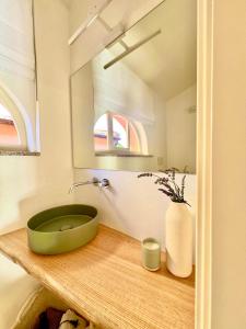 a bathroom with a green bowl on a wooden counter at Il giardino di Gaia in Portoferraio