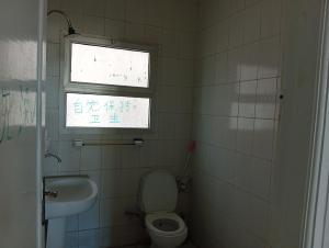 Un baño con inodoro, lavabo y ventana. en Youth Hostel, en Marsa Matruh