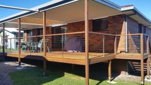 un perro en una jaula en la terraza de una casa en Surfside, en Kioloa