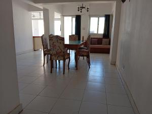comedor con mesa y sillas en el suelo de baldosa en Youth Hostel, en Marsa Matruh