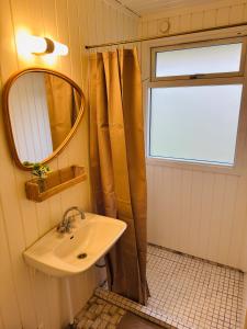 łazienka z umywalką, lustrem i oknem w obiekcie Charming Cottage Near Heatherhill With SPA - Rågeleje w mieście Rågeleje