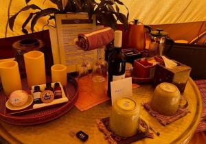 Kanimbia Luxury Glamping في Obi Obi: طاولة عليها زجاجة نبيذ وشموع