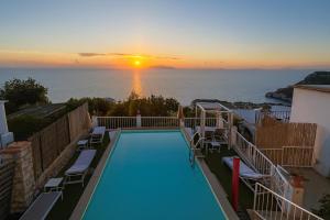 ein Swimmingpool mit Blick auf den Ozean bei Sonnenuntergang in der Unterkunft Vista Mare BB in Anacapri