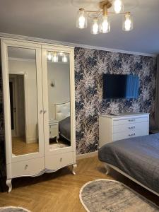 a bedroom with a bed and a dresser with a mirror at Loading Apartments in Chernivtsi +4 photos