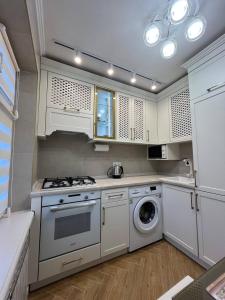 a kitchen with a stove and a washing machine at Loading Apartments in Chernivtsi