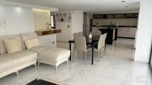 a living room with a couch and a table with chairs at Le Paradisblanc in Kelibia