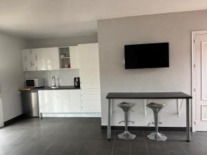 eine Küche mit einem Tisch und einem TV an der Wand in der Unterkunft Sunshine Studio Retreat in Arboleas in Arboleas
