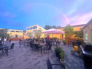 un ristorante con tavoli e sedie con un arcobaleno sullo sfondo di Oasen Samsø a Nordby Altre 136 foto