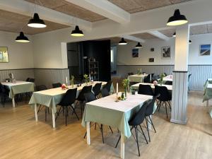 a dining room with white tables and chairs at Oasen Samsø in Nordby