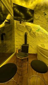 Romantic Chalet with Jacuzzi & Sauna 2- Trebević near Sarajevo في سراييفو: غرفة معيشة مع كرسيين وموقد