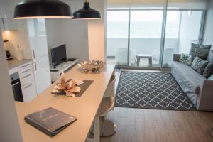 una cucina e un soggiorno con un tavolo e un divano di Islet House a São Roque