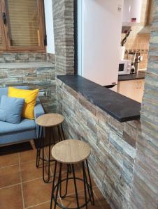 una cocina con dos taburetes junto a un mostrador en Apt Santa Cruz de Caravaca, en Caravaca de la Cruz