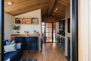 a tiny house with a blue couch and a kitchen at Old Fargie Lodges in Perth
