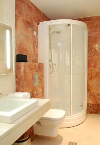 uma casa de banho com um chuveiro, um WC e um lavatório. em Palladion Boutique Hotel em Árgos