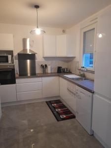 a kitchen with white cabinets and a counter top at Chez Özlem K in Soufflenheim