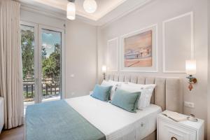 una camera da letto bianca con un letto con cuscini blu di Mk Luxury Apartment a Nauplia