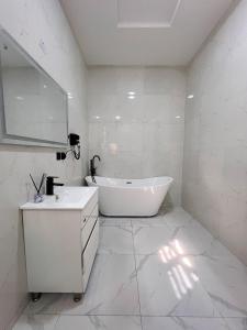a white bathroom with a tub and a sink at Casa Lumière in Lekki