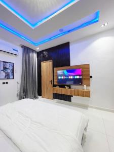 a bedroom with a bed and a tv on a wall at Casa Lumière in Lekki