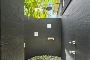 a bathroom with two faucets on a black wall at Sticks by the Sea - pet-friendly coastal home in Manyana