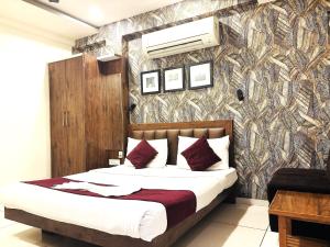 a bedroom with a bed and a wall at Hotel Shree Ram Palace in Indore