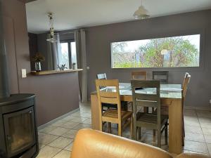 にあるAux Forts Champsのテーブルと椅子と窓のあるダイニングルーム