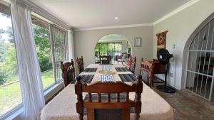 una sala da pranzo con un tavolo e alcune finestre di Oudewerf Fly Fishing on Vaal a Vredefort