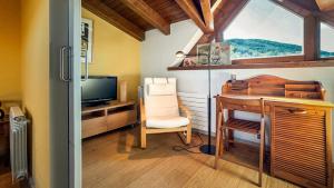 Habitación con escritorio, TV y silla. en Morada la Tosa, en Alp