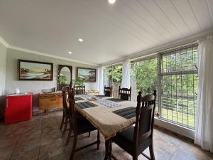 una sala da pranzo con un tavolo e alcune finestre di Oudewerf Fly Fishing on Vaal a Vredefort Altre 24 foto