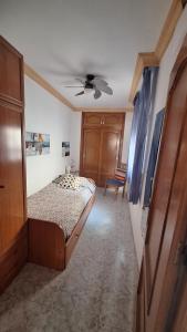 een slaapkamer met een bed en een plafondventilator bij Casa San José in Nerja