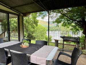 un tavolo e sedie su un patio con griglia di Oudewerf Fly Fishing on Vaal a Vredefort