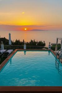 a large swimming pool with a sunset in the background at B&B La Danza del Mare in Anacapri