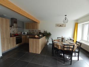 a kitchen and dining room with a table and chairs at Entre Dômes et Sancy - Le moderne in Perpezat